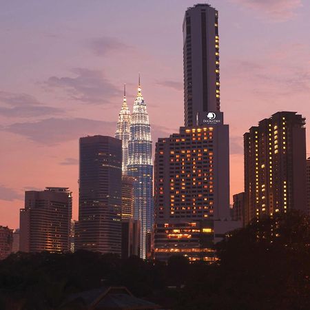 Doubletree By Hilton Kuala Lumpur Ξενοδοχείο Εσωτερικό φωτογραφία The photo showcases a city skyline at dusk, featuring tall buildings against a colorful sunset. Prominent in the image are two tower-like structures, which appear to be twin skyscrapers illuminated in a striking way, suggesting they might be iconic l